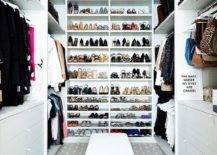 Custom walk in closet features floor to ceiling shoe shelves, built in dressers and a black and white bench on black and white geometric carpeting lit by custom lights.