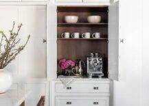 Kitchen features a coffee station in a white cabinet with walnut trim.