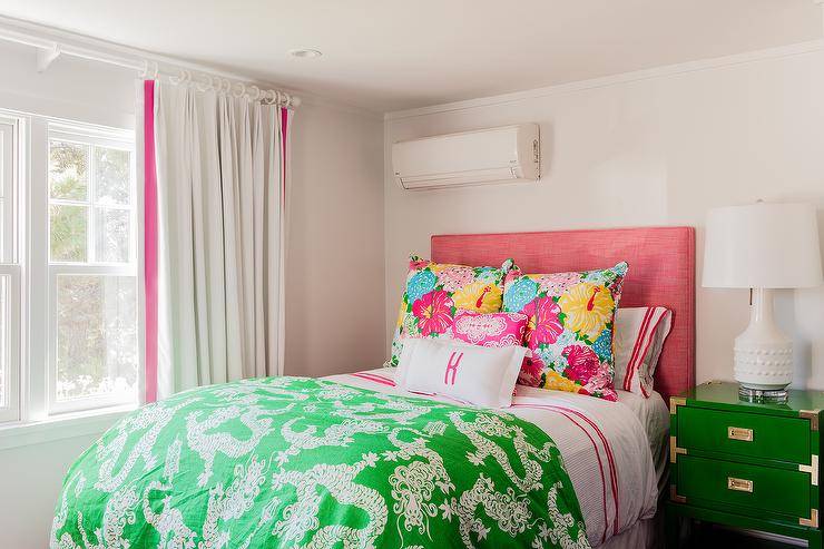 Fantastic pink and green teen girl's bedroom features a pink headboard on queen bed dressed in white and pink hotel bedding and a green Chinese dragon blanket placed next to a single nightstand, green campaign nightstand with brass trim, topped with a Bungalow 5 Mariah White Table Lamp.