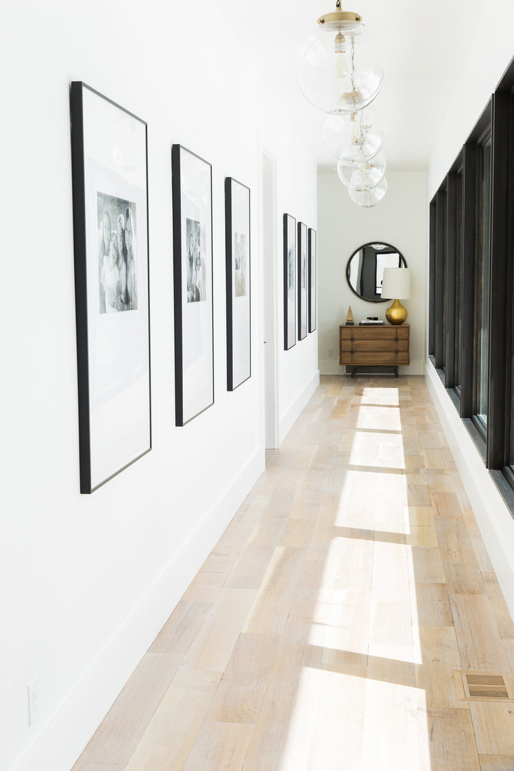 Modern hallway gallery with large black frame pictures.