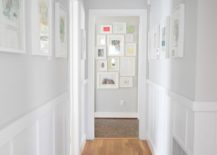 Bright hallway gallery with white framed pictures.