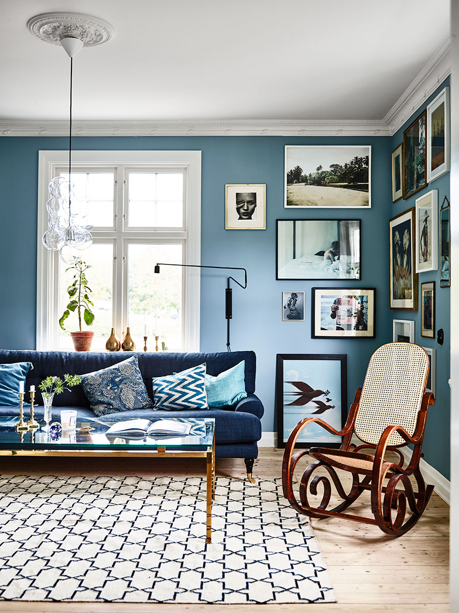 Blue-themed living room with a gallery of pictures.