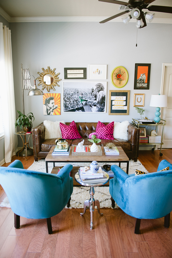 Colorful living room with a gallery that features a unique mirror, art pieces, and quotes.