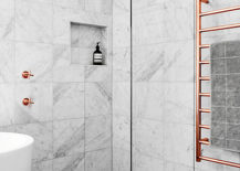 A contemporary bathroom featuring a pristine tub and a shower with copper accents.