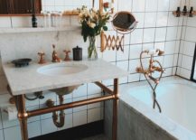 A luxurious bathroom featuring a marble sink and many copper fixtures.