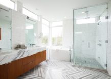 A spacious bathroom featuring a large-sized shower area with a walk-in shower and wood vanity.