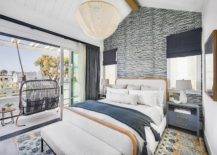 Bedroom features a gray rattan swing on a deck with sliding doors, a white linen bed with wood trim flanked by blue wooden nightstands and white and blue wallpaper.