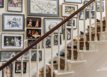 A busy stairway gallery with framed pictures covering almost the entire wall.