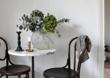 A minimalist room with a white-top table and two black chairs. The chairs are positioned on either side of the table, creating a symmetrical look.