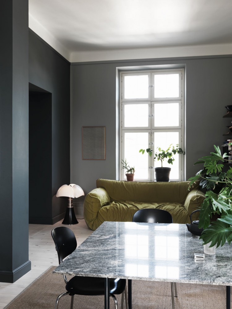 A cozy living room featuring a sleek marble table surrounded by two elegant chairs. The room exudes a warm ambiance with its tasteful decor and inviting atmosphere.