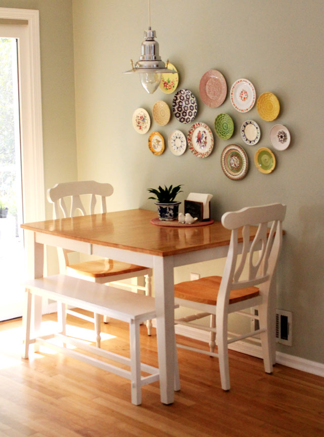 A wooden table is placed in the center of the image. Two white chairs are neatly arranged around the table.