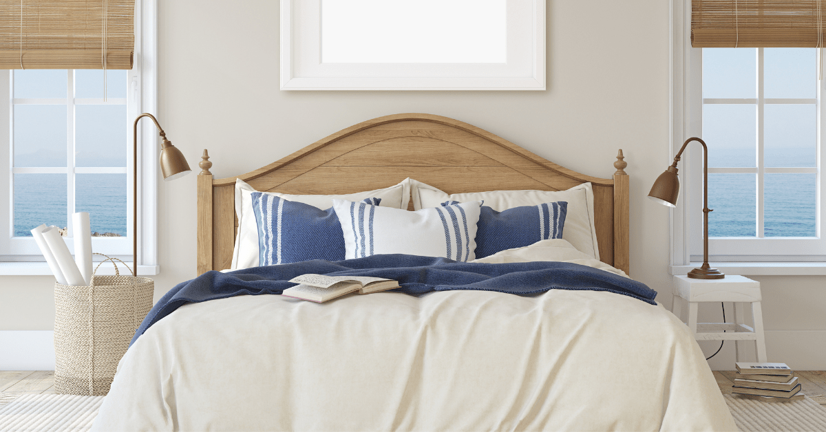 A bedroom with blue throw pillows on bed and wooden accents.