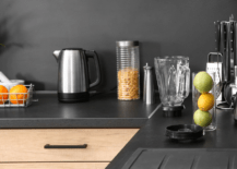 A kitchen with black countertop featuring wooden cabinets.