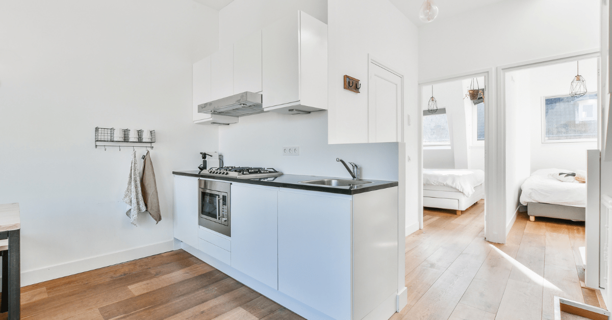 A white kitchen with modern black countertops.