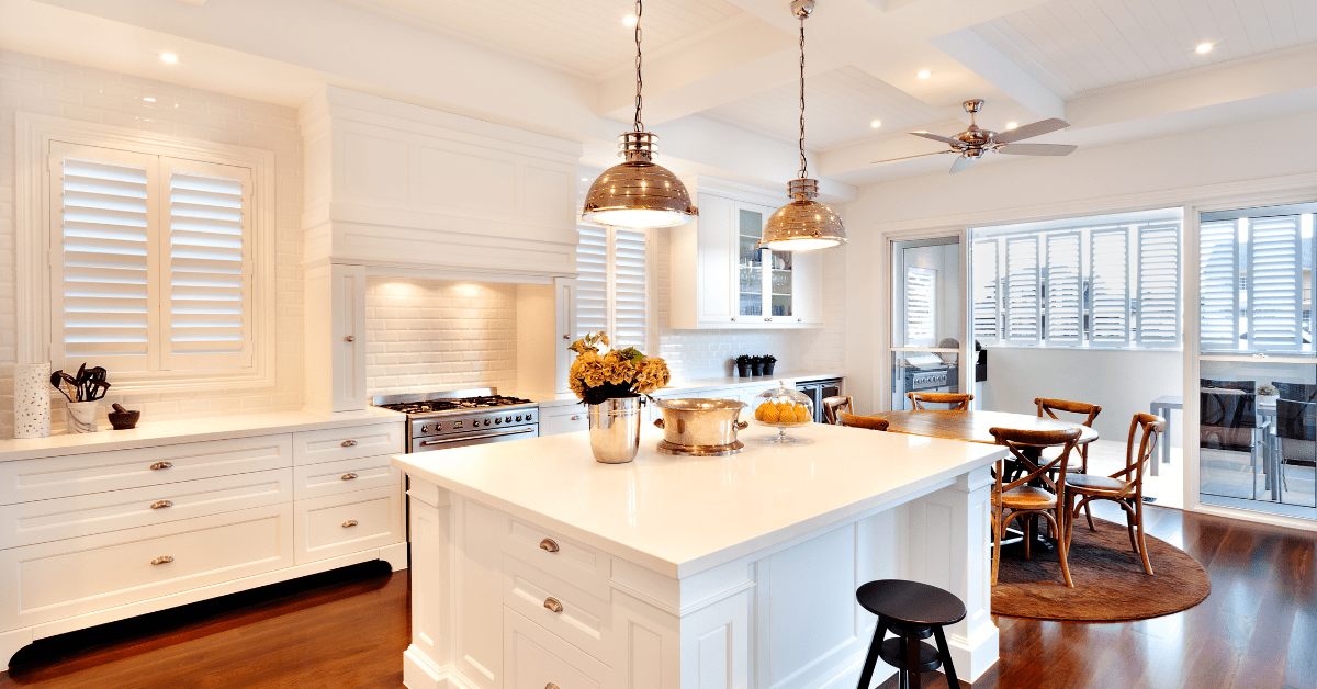 A luxurious kitchen with copper overhead lights above the kitchen island.