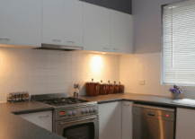 White cabinets pairing with black countertops in modern kitchen.