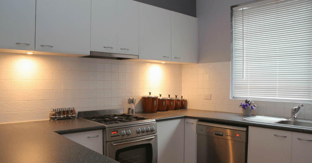 White cabinets pairing with black countertops in modern kitchen.