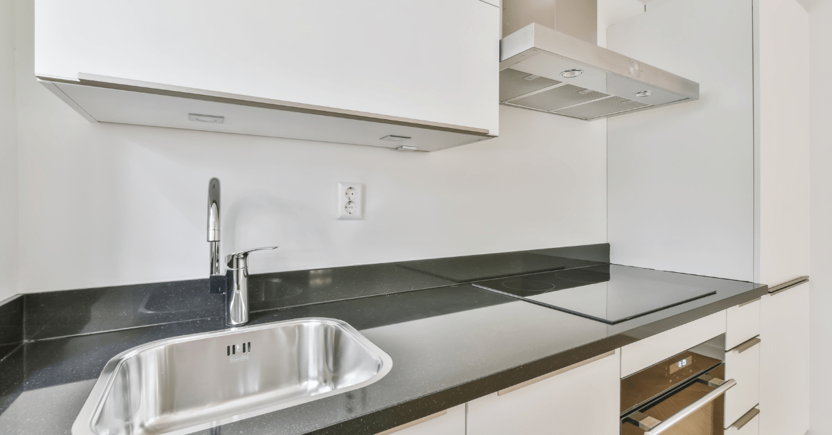 White cabinets with black kitchen countertops.