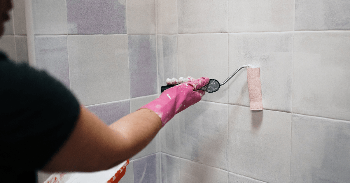 Person repainting tiles in a bathroom.