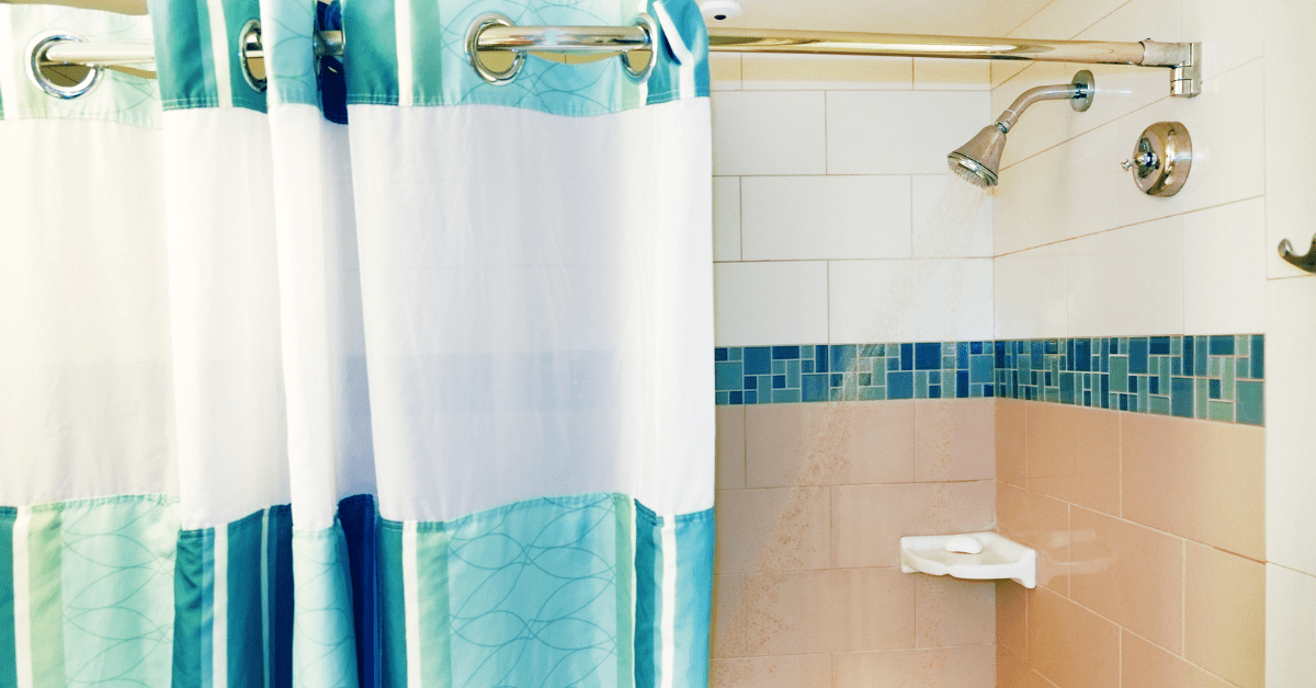 White and blue shower curtain that matches the wall behind it.