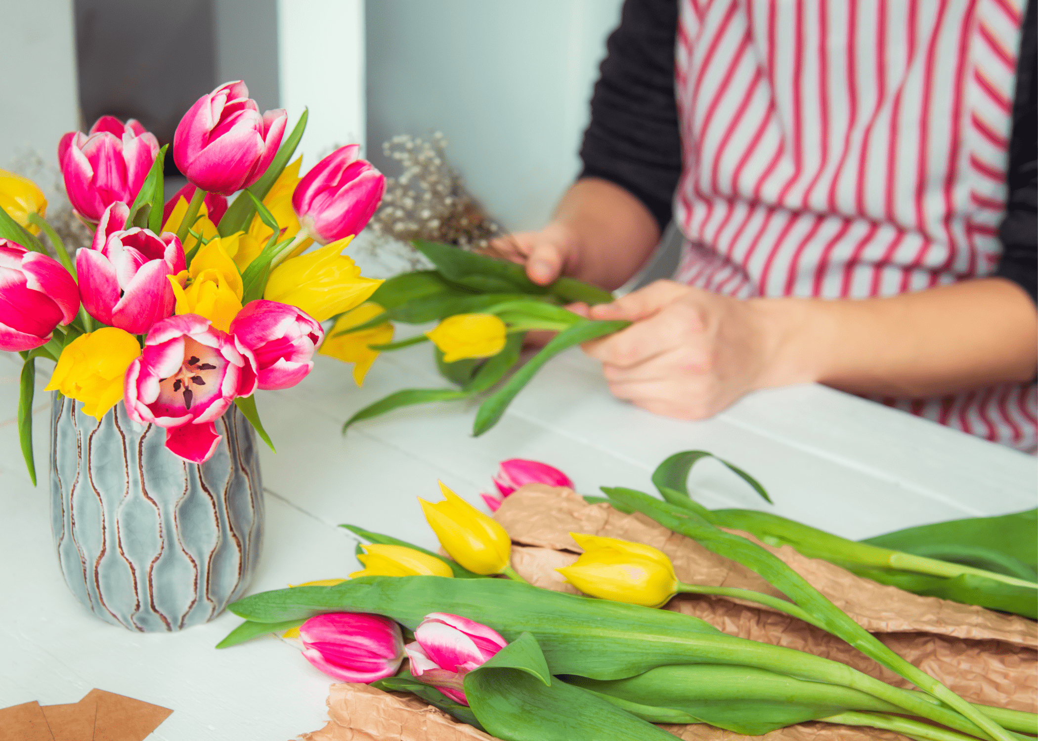 woman arranging tulips in a vase