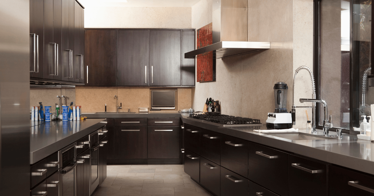 A dark galley kitchen with hardwood cabinets.