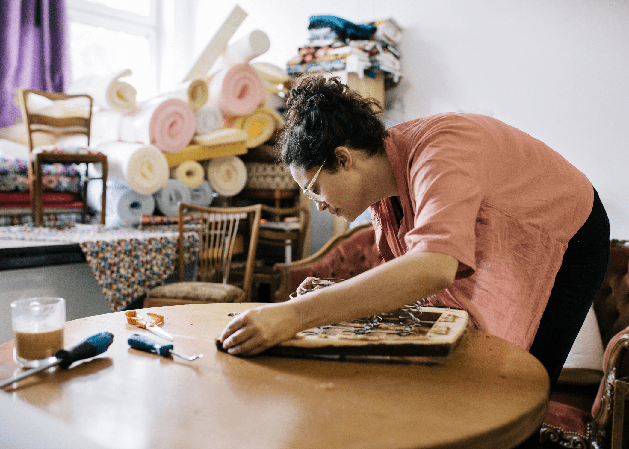 woman working on chair seat reupholstering furniture