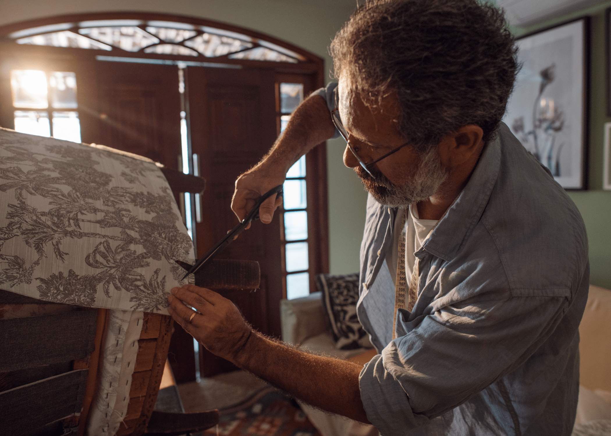 man working on reupholstering a chair