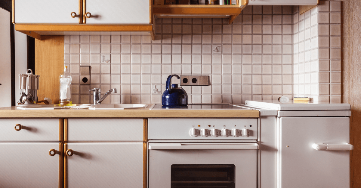 Closeup of white retro kitchen with older applicances.