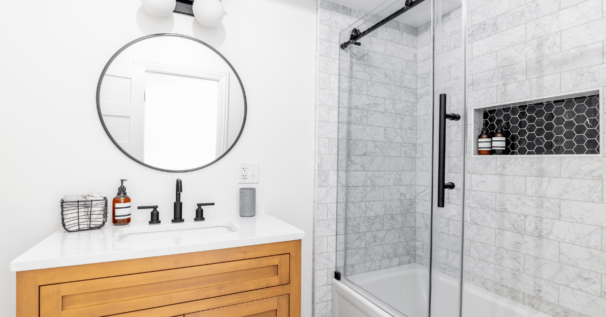 Glass shower with subway tile shower and black fixtures.