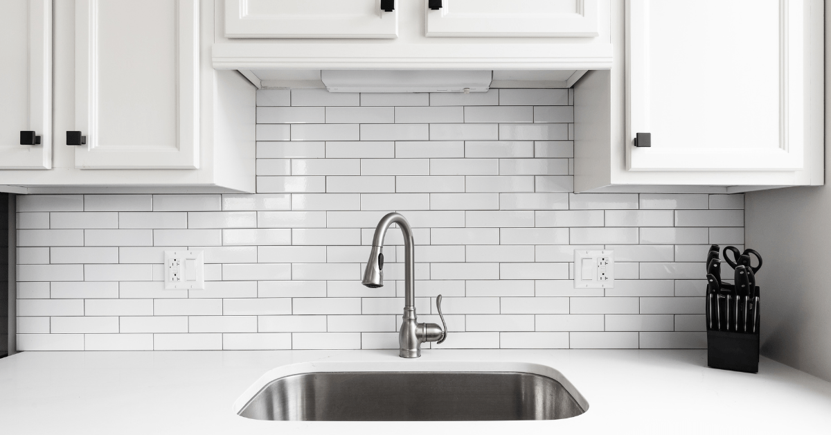 White kitchen with white tile backsplash.