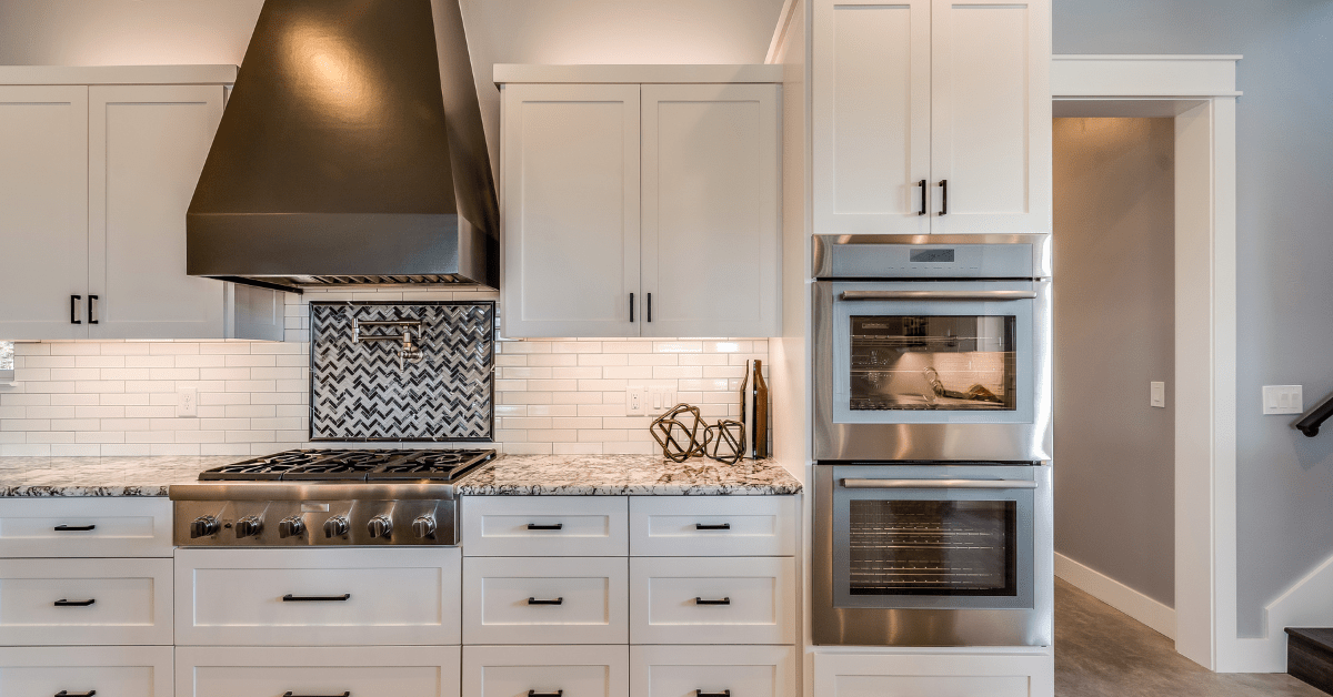 White kitchen with white tile backsplash.